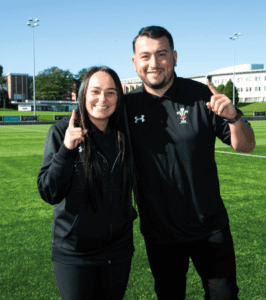 Two Coach Core apprentices stand in training field