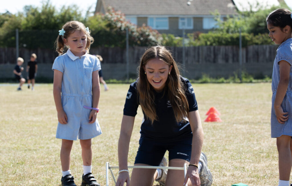 Maia supporting a young participant and building confidence through sport